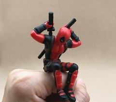 Deadpool em PVC lendo, deitado ou apenas o busto