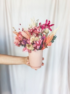 Vaso de cerâmica rosa com arranjo de flores em tons de rosa