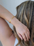 Mulher usando bracelete dourado com dois filetes banhado em ouro 18k.
