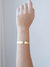 Mulher usando bracelete liso com banho dourado em ouro 18k.