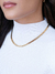 Mulher usando choker de malha fita com fita de 5 mm, com banho dourado em ouro 18k.