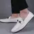 sapato mocassim masculino branco com detalhe em fivela, usado por um homem.