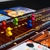 Tabuleiro de um jogo com cinco peças em formatos de coelho coloridos, vermelho, verde, azul, amarelo, rosa e diversas cartas em volta