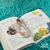 paginas de um livro, com um bebe ilustrado brincando com algumas pecinhas