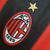 Camisa titular AC Milan 10/11 Adidas: vermelho e preto, com detalhes em dourado pela camisa. Dentro da gola, bandeira da Itália e escrito AC MILAN. Na nuca, bandeira italiana. Logo Adidas e escudo Milan bordados.