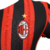 Nova camisa titular do AC Milan 24/25 versão jogador: listras vermelhas e pretas em tom sobre tom, gola e punhos brancos. Escudo e logo PUMA em branco. Costas vermelhas com selo dos 125 anos.