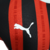 Nova camisa titular do AC Milan 24/25 versão jogador: listras vermelhas e pretas em tom sobre tom, gola e punhos brancos. Escudo e logo PUMA em branco. Costas vermelhas com selo dos 125 anos.