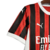 Nova camisa titular do AC Milan 24/25: listras vermelhas e pretas em tom sobre tom, gola e punhos brancos. Escudo e logo PUMA em branco. Costas vermelhas com selo dos 125 anos.