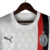 Camisa reserva do Milan 23/24 é branca com duas listras verticais em vermelho e preto. Detalhes em prata por toda camisa. Escudo e logos puma prateados.