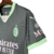 Terceira camisa do AC Milan 2024-2025 PUMA em cinza escuro com detalhes em verde menta nos punhos e gola. Escudo e logo PUMA em menta, patrocínios em 'névoa de uva', selo dos 125 anos na nuca.