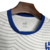 Camisa reserva do Al-Hilal 2024-2025 PUMA é branca com padrão de linhas cinzas, lembrando impressões digitais. Gola azul, com logos PUMA e escudo do Al-Hilal aplicados em azul.