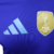 O manto reserva da Argentina destaca o azul royal, homenageando Maradona. As listras celestes nos ombros representam a bandeira. Logos Adidas e AFA em celeste, com o patch de campeã mundial no peito.