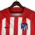 Camisa manga longa titular do Atlético de Madrid adota um design clássico, com listras vermelhas e brancas na frente. Escudo Atletico de Madrid e logo da Nike bordados. A bandeira da Espanha é vista na nuca.