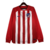 Camisa manga longa titular do Atlético de Madrid adota um design clássico, com listras vermelhas e brancas na frente. Escudo Atletico de Madrid e logo da Nike bordados. A bandeira da Espanha é vista na nuca.