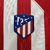 Camisa titular do Atlético de Madrid adota um design clássico, com listras vermelhas e brancas na frente. Escudo Atletico de Madrid e logo da Nike bordados. A bandeira da Espanha é vista na nuca.