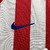 Camisa titular do Atlético de Madrid adota um design clássico, com listras vermelhas e brancas na frente. Escudo Atletico de Madrid e logo da Nike bordados. A bandeira da Espanha é vista na nuca.