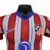 A nova camisa titular do Atlético de Madrid tem listras vermelhas e brancas, separadas por linhas azuis borradas. A gola é mini-polo azul e os punhos vermelhos. O escudo antigo retorna. Logos Nike e Riyadh Air são azuis.