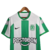 Camisa titular Atlético Nacional 2023 Nike: Camisa com três listras verdes e duas brancas, com detalhes verdes na gola e na barra da manga. Escudo Atletico Nacional de Medellín e logo Nike bordados.