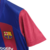 Camisa titular feminina do Barcelona com faixas blaugranas verticais e ombros azuis formando um diamante. Logo Nike e patrocinadores em branco. Escudo com diamante envernizado. Costas listradas e listra catalã na nuca.