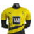 Nova camisa titular do BVB: parte superior amarela e inferior preta, com desenho da "Muralha Amarela". Escudo Borussia Dortmund e logo Puma bordado. Selo "Design datt Ding" na gola e hashtag #BorussiaVerbindet na nuca.