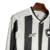 Visão lateral da camisa titular 2024 manga longa do Botafogo. Tem listras verticais com textura em zigue-zague. Gola V branca com bordas pretas e mangas listradas. Escudo alvinegro e logo Reebok em TPU.