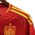 A nova camisa da Espanha para a Euro é vermelha com detalhes amarelos nas laterais, gola e mangas. O design tem ondas em tom mais escuro e um cravo na nuca. O logo da Adidas e o escudo são amarelos.