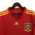 camisa titular da Espanha Adidas masculina 2010: Vermelho predominante, com detalhes em amarelo e friso azul nas mangas. Escudo da Espanha e logo Adidas bordados.