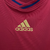 camisa titular da Espanha Adidas masculina 2010: Vermelho predominante, com detalhes em amarelo e friso azul nas mangas. Escudo da Espanha e logo Adidas bordados.