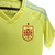 Camisa reserva da seleção espanhola 2024 amarela neon inspirada no sol e verão espanhol. Laterais com ondas azul celeste, arcos vermelhos, três listras nas mangas e faixa na gola. Escudo RFEF amarelo e vermelho no peito esquerdo, logo Adidas no direito.