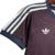 Camisa Espanha coleção de viagem 2024 Adidas: Camisa tem a cor vinho predominante, com detalhes em azul nas mangas e na barra da camisa. Escudo Federação Espanhola, logo Adidas, listras nas mangas e nome da federação em branco.