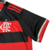 Detalhes da manga da camisa titular 2024 feminina do Flamengo. Preta com punho vermelho e friso prateado. Ao lado, monograma CRF bordado em prata e listras vermelhas nos ombros.