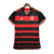 Camisa feminina titular 2024 Flamengo vista de frente: listras rubro-negras mais finas, gola V preta com detalhe vermelho. Ombros pretos, mangas com punhos vermelhos e frisos prateados. Escudo Flamengo e logo Adidas bordados.