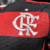 Nova camisa titular Flamengo: listras rubro-negras mais finas, gola V preta com detalhe vermelho. Ombros pretos, mangas com punhos vermelhos e frisos prateados. Laterais e barra traseira vermelhas. Monograma 'CRF' prateado, assim como o logo Adidas.