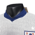 Camisa titular Inglaterra: branca, gola 'semi-polo' azul marinho. Punhos brancos com frisos azul marinho e vermelho. Detalhes azul marinho na manga e laterais. Escudo à esquerda com estrela branca acima, Swoosh Nike à direita em azul marinho.