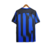 Camisa titular Inter de Milão 2023-2024: Azul com três listras verticais pretas estilo "glitch". Detalhes pretos nos ombros e punhos, gola redonda azul com bandeiras de Milão e Inter. Logo Nike em amarelo, escudo Inter amarelo no lado esquerdo.