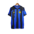 Camisa titular Inter de Milão 2023-2024: Azul com três listras verticais pretas estilo "glitch". Detalhes pretos nos ombros e punhos, gola redonda azul com bandeiras de Milão e Inter. Logo Nike em amarelo, escudo Inter amarelo no lado esquerdo.