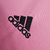 Camisa feminina titular rosa do Inter Miami, chamada "Heartbeat Kit", com gola polo e listras pretas nos ombros. Mangas rosa com punhos com batimentos cardíacos em relevo. Escudo Inter Miami e logo Adidas em preto.