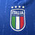 Manto titular da seleção Italiana 2024: azul com curvas brancas nas laterais e listras em relevo. Faixas tricolores nas mangas. Logo Adidas à direita, escudo FIGC à esquerda. Na nuca, frase 'L’Itália Chiamò