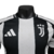 A nova camisa titular da Juventus 24/25 versão jogador mantém o tradicional listrado preto e branco, com leve textura. Gola redonda preta, ombros e mangas brancas, detalhes em preto e três listras. Escudo e logo Adidas bordados.