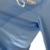 Camisa manga longa titular Manchester City 23/24: azul celeste com faixas verticais em tom sobre tom, inspiradas nas torres do Etihad Stadium. Gola V branca com frisos azul celeste. Escudo do clube e logo puma bordados.