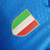 Camisa titular Napoli 23/24: Azul celeste, escudo "N" em jacquard, gola V cruzada com cores da Itália, detalhes brancos, escudo e logo EA7. MSC no patrocínio máster, patch campeão italiano.