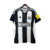 Camisa titular do Newcastle 2024-2025 Adidas com listras verticais preto e branco. Gola V preta, friso branco na nuca. Ombros e mangas pretos com listras brancas. Escudo NUFC, logo Adidas preto. Escudo antigo na nuca.