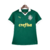 Camisa titular feminina Palmeiras 2024: design clássico, verde predominante, gola pólo e punhos brancos. Três emblemas históricos celebram 110 anos do clube. PUMA estampa felino e patrocinador em dourado, escudo atual no lado esquerdo.