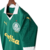 Camisa titular feminina Palmeiras 2024: design clássico, verde predominante, gola pólo e punhos brancos. Três emblemas históricos celebram 110 anos do clube. PUMA estampa felino e patrocinador em dourado, escudo atual no lado esquerdo.