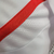 Camisa titular Peru 2023 Adidas. Camisa branca com faixa diagonal vermelha. Gola vermelha, listras nos ombros, punhos brancos com friso vermelho. Escudo seleção peruana e logo Adidas bordados.