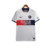 Camisa reserva PSG 2023-2024: predominante branca com faixa horizontal vermelho para azul marinho na barriga, gola e mangas em branco, escudo PSG, logo Nike em azul marinho e bandeira da França nas costas.