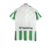 Camisa titular do Real Bétis 2024-2025: listras verticais verde e branco, padrão brilhante inspirado nos anos 90. Gola polo branca com detalhes serrilhados em verde, logo Hummel em branco e chevrons nos ombros.