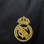 Nova camisa três do Real Madrid: preta, versátil e elegante. Três listras cinzas nas mangas, gola redonda com abertura de botão e iniciais RMCF costuradas em amarelo. Escudo amarelo e logo Adidas bodados.