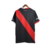 Camisa preta do River Plate com faixa diagonal vermelha. Gola V bicolor (branca e vermelha), três listras nos ombros e punhos seguindo a mesma divisão de cores. Escudo River Plate e logo Adidas bordados. Na nuca, a palavra 'Grandeza'.