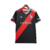 Camisa preta do River Plate com faixa diagonal vermelha. Gola V bicolor (branca e vermelha), três listras nos ombros e punhos seguindo a mesma divisão de cores. Escudo River Plate e logo Adidas bordados. Na nuca, a palavra 'Grandeza'.